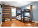 Bedroom with hardwood floors, bunk beds, and wood-paneled walls at 200 Cleveland Ave, Shelby, NC 28150