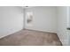 A simple bedroom with one window, neutral carpet and a door to the left at 2715 Ballade Dr, Matthews, NC 28105