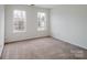 A simple bedroom with neutral carpet and two bright windows at 2715 Ballade Dr, Matthews, NC 28105