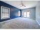 Spacious bedroom with a ceiling fan, two windows and blue accent wall at 615 Real Quiet Ct, York, SC 29745