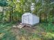 White metal storage shed with wooden ramp in wooded backyard at 615 Real Quiet Ct, York, SC 29745