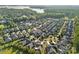 Expansive aerial view of a well-manicured community near a lake surrounded by lush greenery and mature trees at 16115 Lakeside Loop Ln, Cornelius, NC 28031