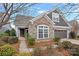 Beautiful home featuring a stone facade, gray siding, manicured landscaping, and attached two car garage at 16115 Lakeside Loop Ln, Cornelius, NC 28031