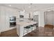 Modern kitchen with stainless steel appliances, a quartz countertop island, hardwood floors, and sleek cabinets at 16115 Lakeside Loop Ln, Cornelius, NC 28031