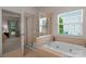 Bathroom with a shower and bathtub, and view into bedroom at 2024 Holly Villa Cir, Indian Trail, NC 28079