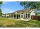 Backyard view of house with large sunroom addition at 2024 Holly Villa Cir, Indian Trail, NC 28079