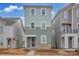 Three-story townhome with light green siding and brick accents at 207 Davidson Gateway Dr, Davidson, NC 28036