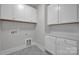 Bright laundry room with white cabinets and patterned floor at 207 Davidson Gateway Dr, Davidson, NC 28036