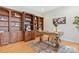 A home office featuring built-in bookshelves and a classic wooden desk on hardwood floors at 3015 Duclair Ln, Fort Mill, SC 29707