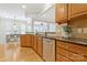 An open kitchen showcases wood cabinets, a granite countertop, a stainless steel dishwasher, and an open layout to dining at 3015 Duclair Ln, Fort Mill, SC 29707