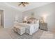 Inviting main bedroom showcases a tray ceiling, neutral colors, and matching bedside tables. Ensuite bathroom in the background at 3015 Duclair Ln, Fort Mill, SC 29707