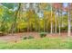 View of wooded property with trees in autumn colors along with a lawn area and split rail fence on the border at 138 Huntly Ln, Mooresville, NC 28115