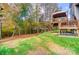 Backyard view shows the upper deck with pergola along with a treelined backdrop of tall deciduous trees at 138 Huntly Ln, Mooresville, NC 28115