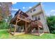 View of backyard deck with shaded lounge area, stairs to lower level, lawn, and house with neutral siding at 138 Huntly Ln, Mooresville, NC 28115