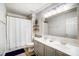 Bright bathroom with a double vanity, large mirror, white shower curtain, and wood-look floors at 138 Huntly Ln, Mooresville, NC 28115