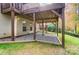 View of backyard patio with stairs to upper deck; neutral siding, and the yard is surrounded by colorful fall foliage at 138 Huntly Ln, Mooresville, NC 28115