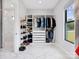 Custom closet with ample shelving and hanging space, bright light, and marble floors for optimal organization at 2109 Goose Creek Farm Ln, Indian Trail, NC 28079