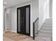 Modern entryway with a statement black double door, staircase, and clean lines for a welcoming first impression at 2109 Goose Creek Farm Ln, Indian Trail, NC 28079