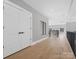 Hallway with hardwood floors, white double doors, and natural light at 2109 Goose Creek Farm Ln, Indian Trail, NC 28079