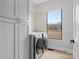 Modern laundry room with gray cabinets and large window at 2109 Goose Creek Farm Ln, Indian Trail, NC 28079