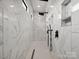 Large walk-in shower with marble tile and two shower heads at 2109 Goose Creek Farm Ln, Indian Trail, NC 28079