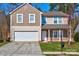 Two-story house with neutral siding, stone accents, and a two-car garage at 3308 Lemongrass Ln, Charlotte, NC 28214