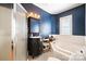 Bathroom with soaking tub, shower, and dark vanity at 515 S Academy St, Lincolnton, NC 28092