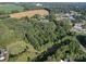 Aerial view of a wooded lot with a curved driveway, near other buildings at 1116 Medlin Rd, Monroe, NC 28112