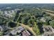 Aerial view showing a property lot with surrounding trees and nearby buildings at 1116 Medlin Rd, Monroe, NC 28112