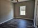 Cozy bedroom featuring dark laminate flooring, neutral walls, and a window offering natural light and views at 2054 Cane Mill Rd, Lancaster, SC 29720