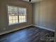 Bright bedroom with dark laminate flooring, neutral walls, and a large window overlooking the landscape at 2054 Cane Mill Rd, Lancaster, SC 29720