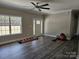 Bright living room showcasing dark laminate flooring, a modern ceiling fan, and a window view of the outdoors at 2054 Cane Mill Rd, Lancaster, SC 29720