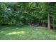 Lush backyard with mature trees and greenery, featuring a trailer at 2840 Wheat Field Ct, Lincolnton, NC 28092