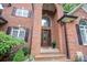 Elegant brick home entrance featuring a decorative glass door, arched windows and lush landscaping at 2840 Wheat Field Ct, Lincolnton, NC 28092