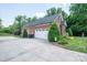 Spacious two-car garage with a brick exterior, surrounded by lush landscaping and mature trees at 2840 Wheat Field Ct, Lincolnton, NC 28092