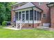 Cozy screened porch with white trim, accessed by stairs, adjoins a brick patio and backyard at 2840 Wheat Field Ct, Lincolnton, NC 28092