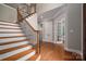 Staircase with hardwood treads and iron spindles, flowing into a hallway with multiple doorways and hardwood floors at 2840 Wheat Field Ct, Lincolnton, NC 28092