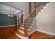 Open staircase features wood treads and black iron spindles, complemented by hardwood flooring and ample natural light at 2840 Wheat Field Ct, Lincolnton, NC 28092