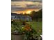 Beautifully landscaped backyard with flower gardens and a wrought iron fence at sunset at 7456 Hartsfield Dr, Lancaster, SC 29720