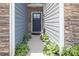 Inviting front entrance with stone veneer, landscaped planters, and a stylish black door at 7456 Hartsfield Dr, Lancaster, SC 29720