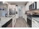 Open kitchen with stainless steel appliances, granite countertops, and white cabinetry at 7456 Hartsfield Dr, Lancaster, SC 29720