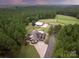 Stunning aerial view of a large country estate with mature trees, fencing, barn and expansive lawn at 1046 Sutton Spring Rd, York, SC 29745