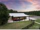 Spacious barn featuring covered parking with a boat, set against a beautiful sunset backdrop at 1046 Sutton Spring Rd, York, SC 29745