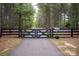 Automated entrance gate and fence nestled among tall pine trees on a long driveway to the home at 1046 Sutton Spring Rd, York, SC 29745