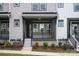 Charming gray townhouse featuring a covered front entrance with black rails and well-maintained landscaping at 429 Nathaniel Way # Brx0032, Charlotte, NC 28213