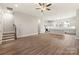 Bright living room with hardwood floors, a ceiling fan, and stairs leading to the upper level of the home at 429 Nathaniel Way # Brx0032, Charlotte, NC 28213