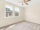 Well-lit bedroom with neutral carpet and two large windows offering ample natural light and neighborhood views at 433 Nathaniel Way # Brx0033, Charlotte, NC 28213