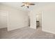 Bright bedroom featuring neutral carpet, ceiling fan, closet, and ensuite bathroom for optimal comfort at 433 Nathaniel Way # Brx0033, Charlotte, NC 28213