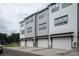 Row of townhouses with white garage doors and neutral-colored siding, complemented by black awnings and well-maintained curb appeal at 433 Nathaniel Way # Brx0033, Charlotte, NC 28213