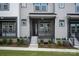 Charming gray townhouse featuring a covered front porch with dark trim, complemented by manicured landscaping and a well-maintained lawn at 433 Nathaniel Way # Brx0033, Charlotte, NC 28213